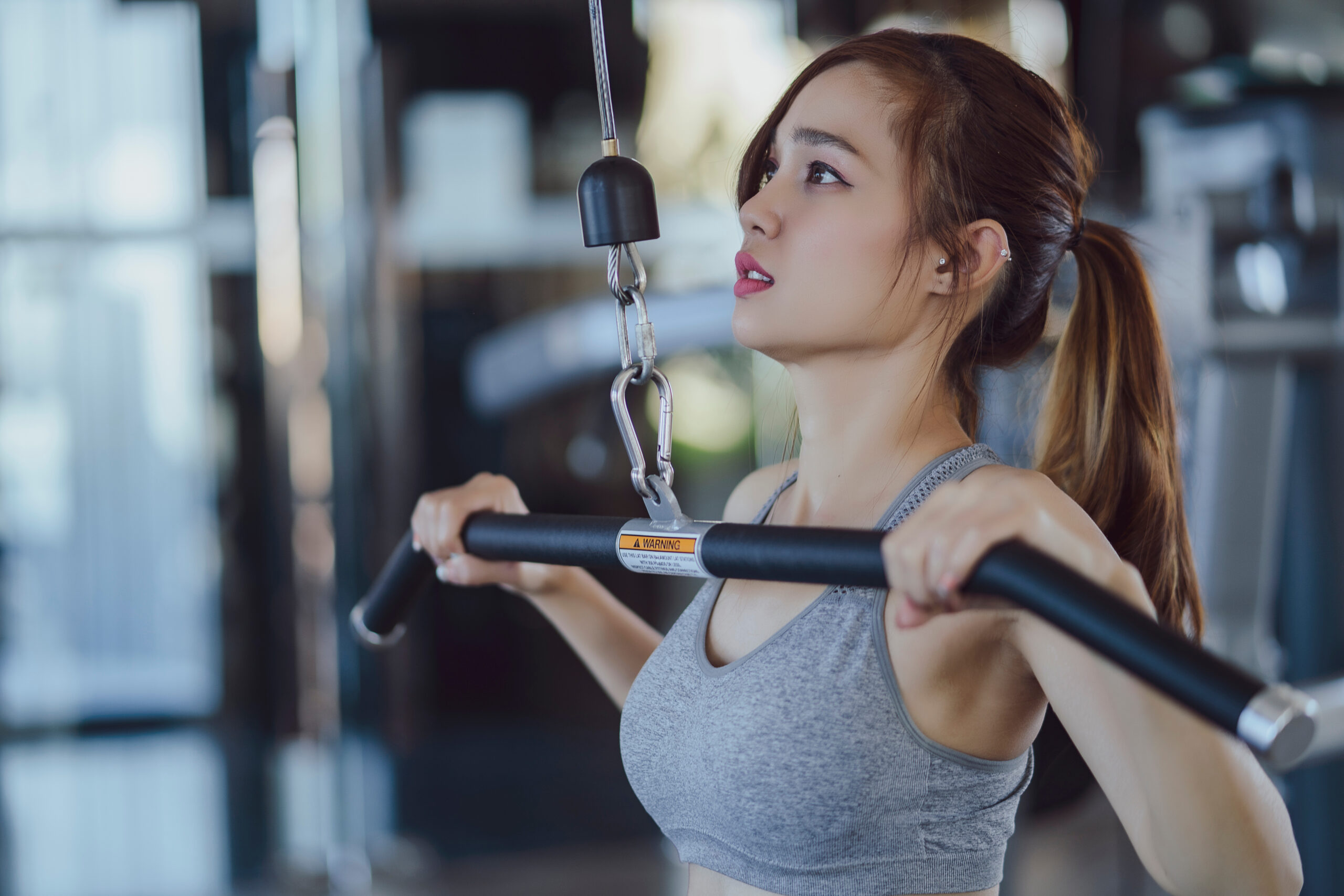 fitness new normal, Woman at the gym on a sports simulator., Fit beautiful young woman exercise workout on machine in gym. Glad smiling girl is enjoy with her training process. Concept of fitness, Hea